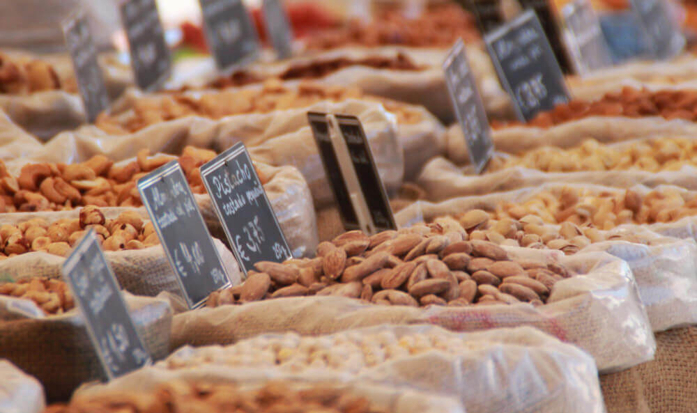 Varietà di frutta secca sfusa in sacchi di juta.